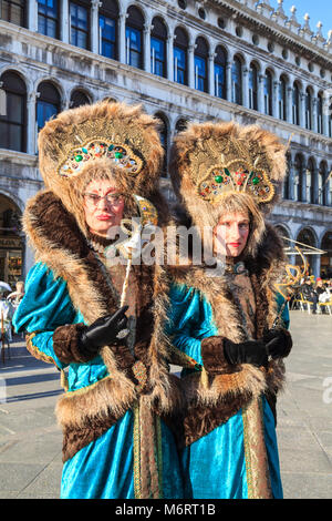 People in beautiful fancy dress costumes and mask on St Mark's Square at the Venice Carnival, Carnivale di Venezia, Veneto, Italy Stock Photo
