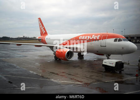 easyjet airbus319 aircraft g-ezdk on stand at belfast international airport in the rain