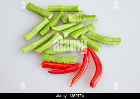 Group of red hot chilli and cow-pea (long bean) chopped on white background - top view, closed up Stock Photo