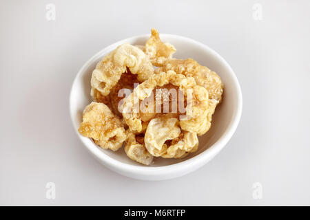 Crispy pork skin (pork rind) in the small bowl, white background - top view, close up, isolated Stock Photo
