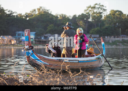 Tourists on wooden boats waiting to photograph the sunset over U Bein bridge. Amarapura, Myanmar (Burma). Stock Photo