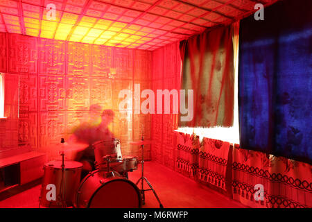 music, passion, creation concept. in the isolated room that is illuminated by bright bloody red light there is blurred figure of male musician playing Stock Photo