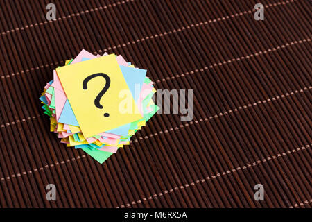 question marks written reminders tickets on wooden background. Stock Photo