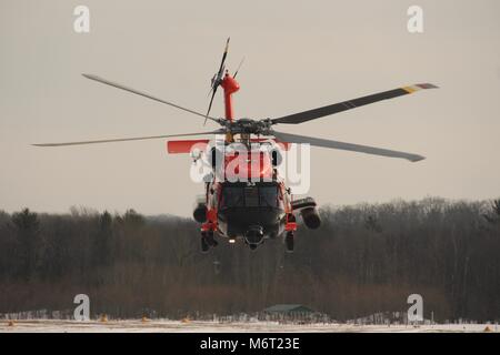 An MH-60 Jayhawk Helicopter crew from Coast Guard Air Station Traverse City practices snow landing training at Green Lake Airport, in Interlochen, Michigan, February 15, 2018. The larger, more capable MH-60 Jayhawk replaced the MH-65 Dolphin helicopters at Air Station Traverse City in the early summer of 2017. (U.S. Coast Guard photo by Seaman Brendan Stainfield) Stock Photo