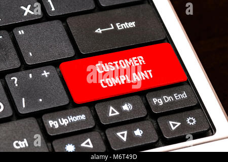 On the laptop keyboard the red button written Customer complaint. Stock Photo