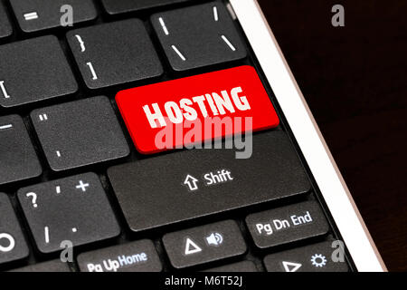 Hosting on Red Enter Button on black keyboard. Stock Photo