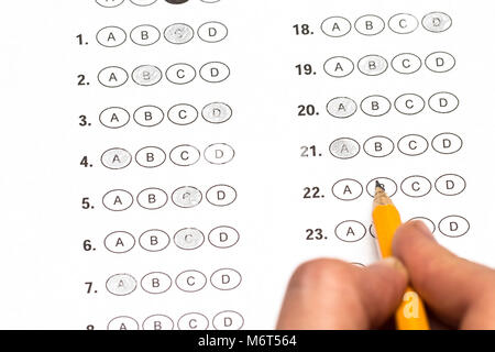 hand fill in Exam papers sheet and pencil. Stock Photo