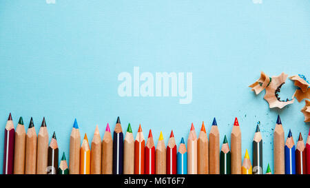 colored pencils and pencil shavings on blue background. Stock Photo
