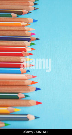 colored pencils on blue background, vertical image Stock Photo