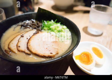 Traditional Japanese soup ramen with meat broth, asian noodles, seaweed, sliced pork, eggs and pickled ginger. Background. Asian style food. Stock Photo