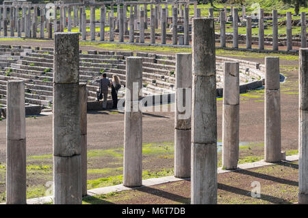 Visitors surveying the stadium surrouded by ancient  columns of the stoa, at Ancient Messene, Messinia, Peloponnese, Greece Stock Photo