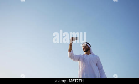 Portrait of Arabian sheikh man with gadget that communicates in  Stock Photo