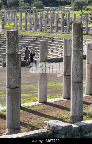 Visitors surveying the stadium surrouded by ancient  columns of the stoa, at Ancient Messene, Messinia, Peloponnese, Greece Stock Photo