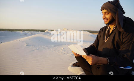 Handsome arabic male architect looks at documents and sits on sa Stock Photo