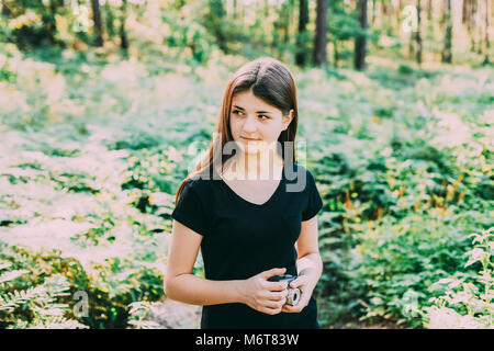 Happy Young Red-haired Caucasian Teenage Girl Photographer Taking Pictures The Old Retro Vintage Film Camera In Summer Green Forest. Girl Dressed In A Stock Photo