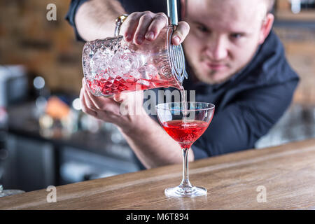 Barman in pub or restaurant  preparing a cocktail drink. Stock Photo