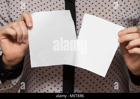 Female hands tearing a sheet of paper, closeup. Stock Photo