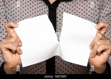 Female hands tearing a sheet of paper, closeup. Stock Photo