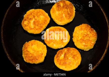 Fried curd cheese pancakes, cheesecakes in frying pan, close up view. Stock Photo