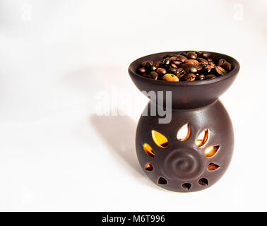 tea light candle heat oil perfume diffuser with coffee beans on the top. for aroma therapy concept Stock Photo