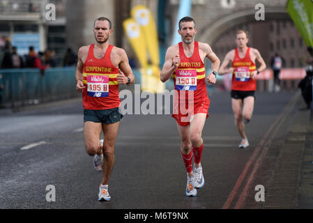 Serpentine club runners Chris Oddy 195 and Will Green 150 running in the Vitality Big Half marathon crossing Tower Bridge, London Stock Photo