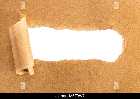 holes in brown paper with torn sides over paper background with space for text. Stock Photo
