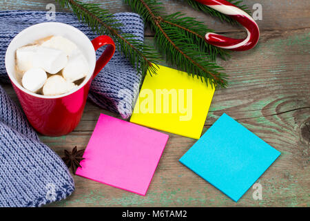 Blank colored sticky notes  ready for message and cup of coffee  with decoration on wooden board. Stock Photo