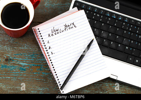 New year's resolutions written on paper on top of laptop keyboard. Stock Photo