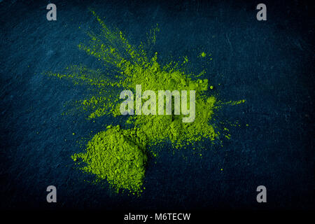 Heap of matcha green tea on dark slate background, top-view, close-up. Stock Photo