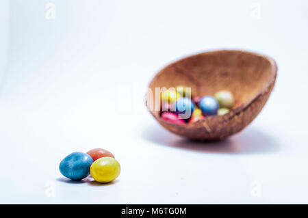 Escaping the Den. A small candy dish full of brightly colored candys. Escape concept. A few are leaving from the others. Stock Photo