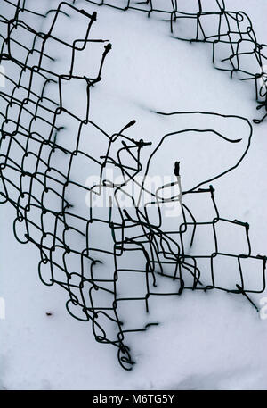 Damaged chain link fencing in snow, UK Stock Photo