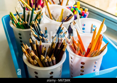 Coloured pencils in window light grouped by colour Stock Photo