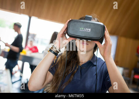 Woman uses a virtual reality headset to see the far corners of space ...