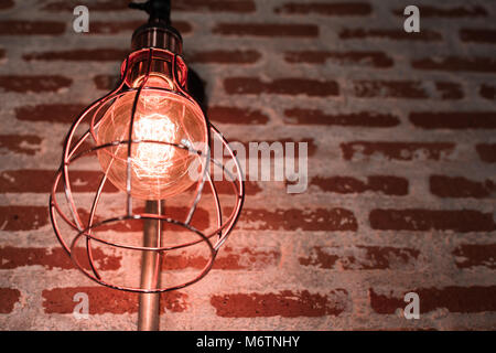 Decorative antique edison style light bulbs against brick wall background Stock Photo