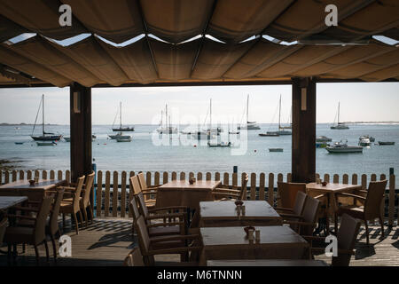 A restaurant overlooking boats in the bay at Corralejo, Fuerteventura in the Canary Islands. Stock Photo