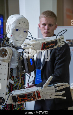 A young scientist testing an anthropoid robot at the Robostation, at Moscow's VDNKh Exhibition Center in Russia Stock Photo