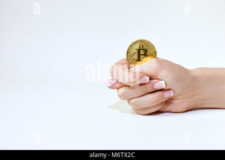 Female hand holds bitcoin and shows fig. Stock Photo