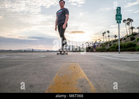 Low view of skater at Long Beach coming towards camera with line in view Stock Photo