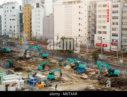 Large active building construction site. In Asia, with all visible brands, signage removed. Workers in action, but no identifiable features. Stock Photo