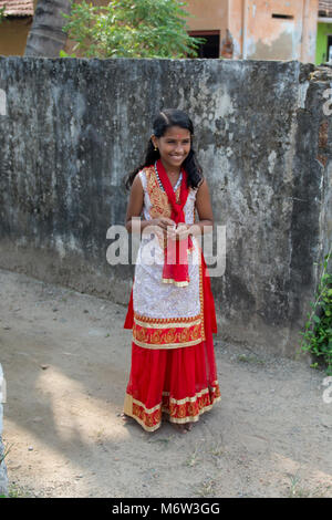 Smiling happy young Indian girl in red white and gold traditional dress in Kerala, India Stock Photo