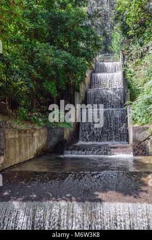 Man made waterfall with clean water running down the cascade concrete structure. Part of ecology friendly irrigation system of Madeira island, Portuga Stock Photo