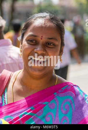 Portrait of a smiling Indian woman wearing a pink, purple and green sari (saree) in New Delhi, India Stock Photo