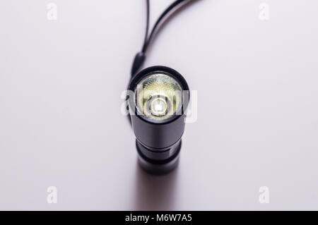Torch with hand strap isolated on white background. LED aluminium flashlight. Black torch. Stock Photo