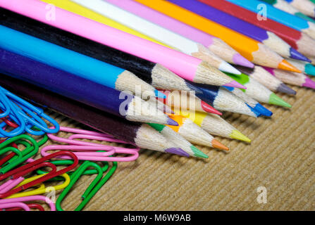 a lot of colorful penciles set in a row with  paper clips Stock Photo