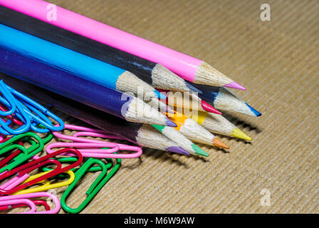 a lot of colorful penciles set in a row with  paper clips Stock Photo