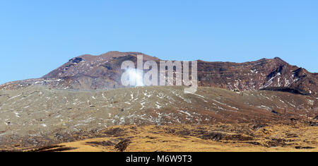 Mt. Aso volcano with the Nakadake crater spewing sulfur steam. Stock Photo