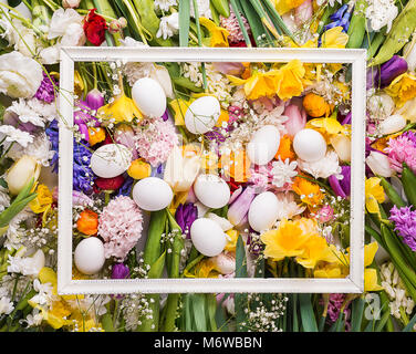 Colorful flowers and white eggs background. Stock Photo