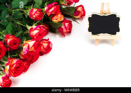 Red roses and a black board on white background with copy space. Stock Photo
