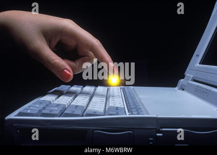 1994 HISTORICAL WOMANS HAND OVER MECHANICAL KEYBOARD OF TOSHIBA T1910CS SATELLITE LAPTOP NOTEBOOK COMPUTER (©TOSHIBA CORP 1994) Stock Photo