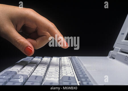 1994 HISTORICAL WOMANS HAND OVER MECHANICAL KEYBOARD OF TOSHIBA T1910CS SATELLITE LAPTOP NOTEBOOK COMPUTER (©TOSHIBA CORP 1994) Stock Photo